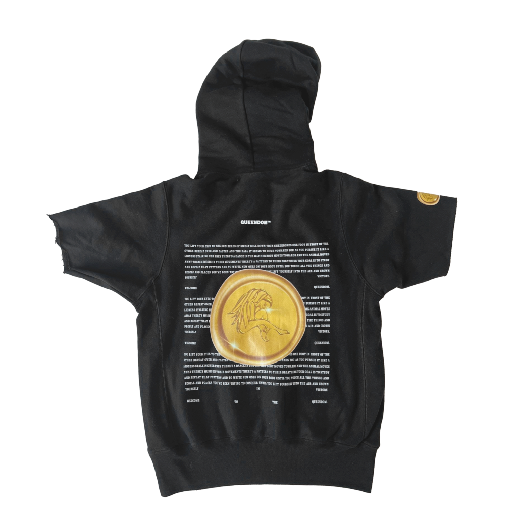 Studio shot of black Casa Malka hoodie with large gold coin emblem on the back